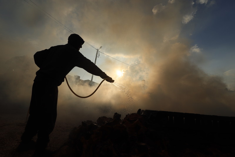 Destruction following a settler attack that killed four Palestin Een Palestijn blust een vuur na een aanval van een kolonist waarbij drie Palestijnen werden gedood en een vierde werd gedood door een soldaat, in Qusra, een dorp in de buurt van de noordelijke stad Nablus op de Westelijke Jordaanoever, op 11 oktober 2023. - Foto: Wahaj Bani MouflehActiveStills